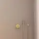 Brausearmatur von Ideal Standard in Brushed Gold, montiert an einer schlichten, hellen Wand. Enthält eine Handbrause und eine Reguliervorrichtung.